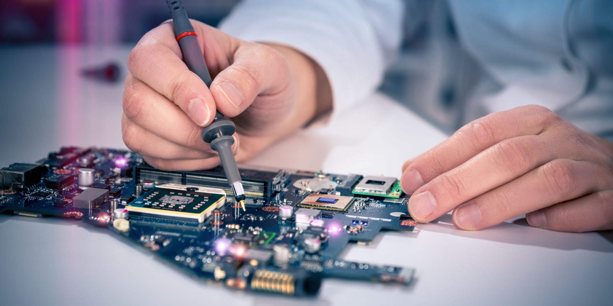 tech fixes motherboard in service center. shallow dof, focus on hands, image is toned with extra light effects