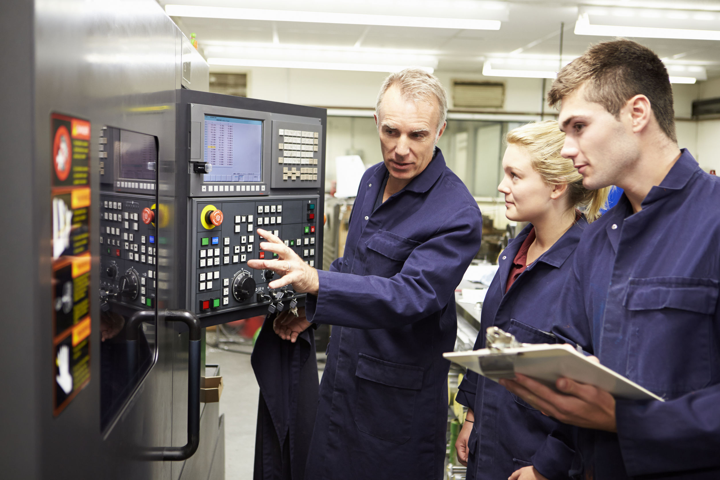 Engineer Teaching Apprentices To Use Computerized Lathe