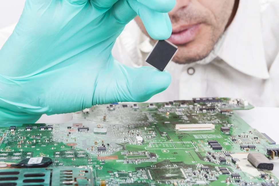 Holding Microchip on electronic circuit board with Gloves Holding Microchip on electronic circuit board with Gloves
