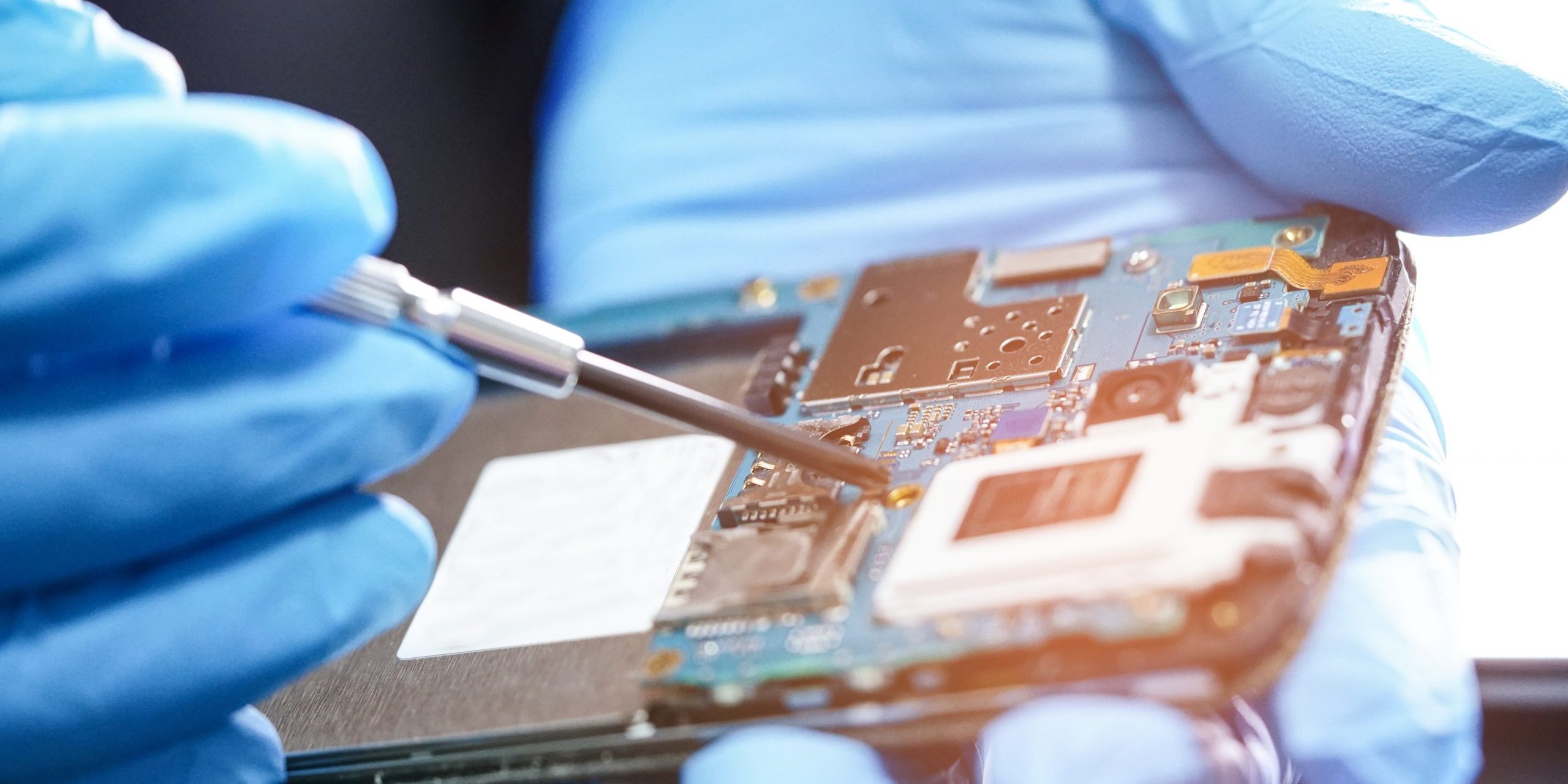 Technician repairing micro circuit main board of smartphone electronic technology : computer, hardware, mobile phone, upgrade, cleaning concept.