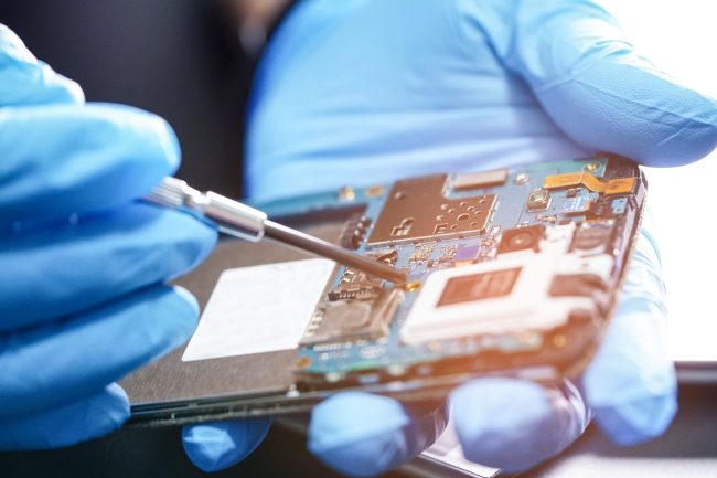 Technician repairing micro circuit main board of smartphone electronic technology : computer, hardware, mobile phone, upgrade, cleaning concept.