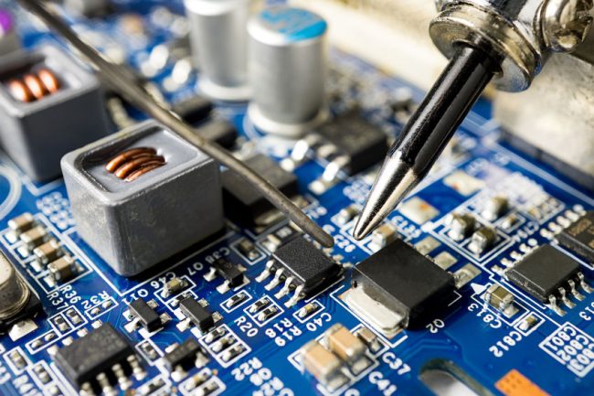 ipc training center soldering a circuit board with iron and lead