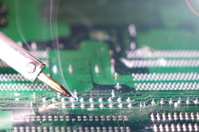 94363385_m_normal_none Soldering to a circuit Board of a computer close up